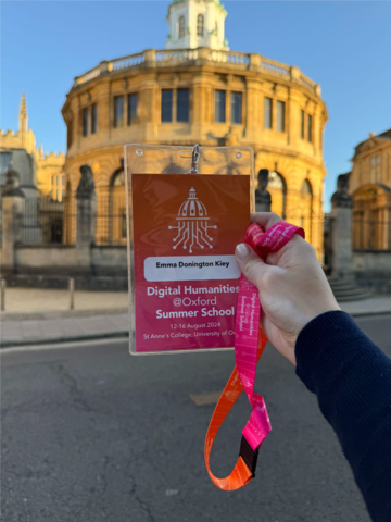 A summer school lanyard badge held up in front of the Sheldonian Theatre