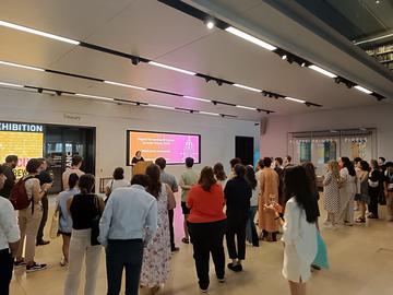 A group of people in Blackwell Hall looking towards a speaker at a lectern