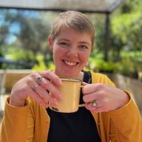 Andri Johnston smiling and holding a mug