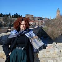 Elena Caetano Alvarez standing in front of a city landscape.